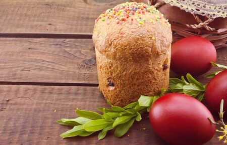 Easter cake and red eggs on rustic wooden table