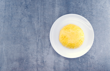 Italian traditional Polenta, porridge made from cornmeal. Mamaliga on rustic background. Organic...