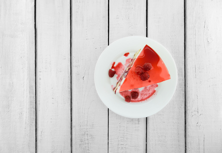 Slice of vanilla sponge cake with yogurt souffle and raspberry jelly. Sweet food for holiday. Top view.の写真素材
