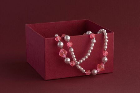 Red box with beads on colored backgroundの写真素材