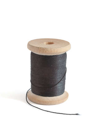 Spool with black thread isolated on whiteの写真素材