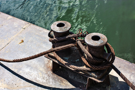 Old rusty mooring rope on an iron pierの写真素材