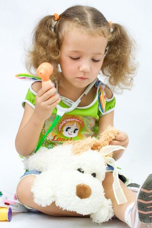 The girl plays in the doctor with toy toolsの写真素材