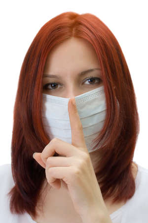 The girl in a medical mask, gesture asks silence, isolated over whiteの写真素材