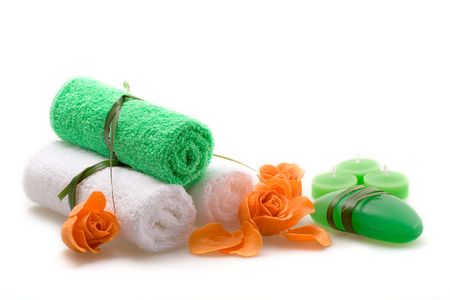 Spa concept of green color: the towel, soap and candles over white backgroundの写真素材