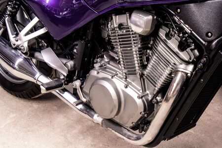 Silver v-twin shaped engine of sports motorcycle close-up. Pistons, cylinders, pedals, gearbox, back wheel motorbike. Chrome motor parts. Repair, bike maintenance in the garage.の写真素材