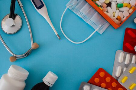colorful tablets and capsules in box, statoscope, medical mask, antiseptic bottle, container,...