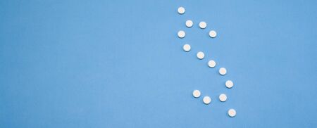 White pills, drugs on blue background. Prevention of . Web banner on site with empty space for text...