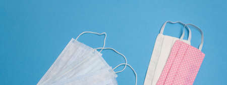 Five beautiful colored different medical masks on blue isolated background. Hygienic, antimicrobial,...