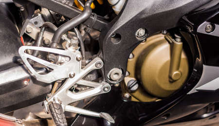 Gold engine of motorcycle close-up. Sport silver-black bike, top side view. Motorcycle internal...