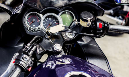 View of steering wheel of modern sports motorcycle. Pointer speedometer, tachometer with keyhole and...