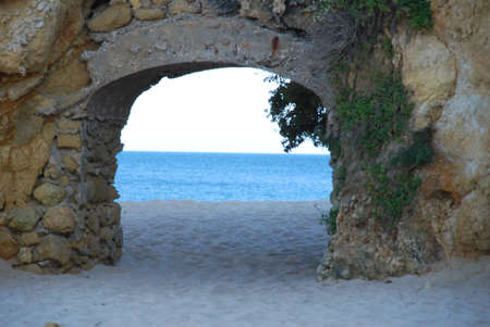 Stone Archway on a White Sand Beach in Portugalの写真素材