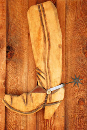 Wooden Cowboy Boot with Spur on Wooden Wallの写真素材