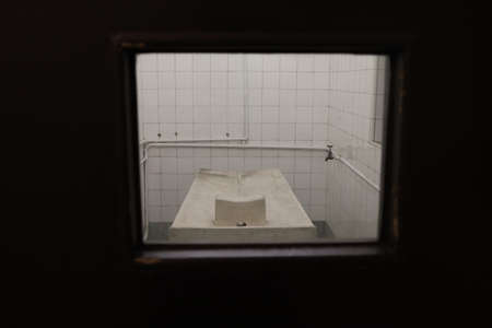 A vertical shot of a washbasin in a room with a window