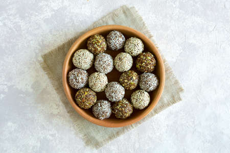 Healthy vegetarian balls with cashews, hazelnuts, peanut butter and almond in the clay plate on the...