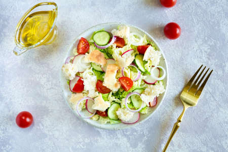 Salad fattoush. Healthy vegetarian food. Traditional Middle Eastern salad with toasted pita bread and vegetables in the white plate on the napkin. Close up.の写真素材