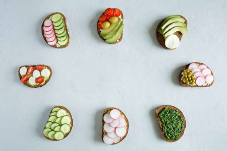 Different vegetable sandwiches on the gray background. Healthy food. Product ready to eat. Frame...