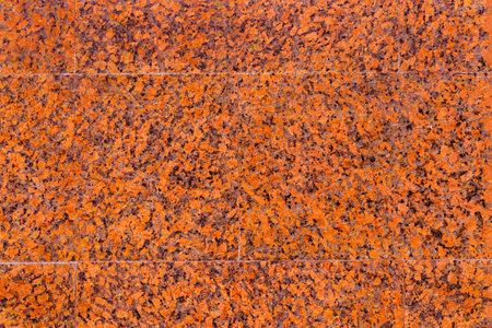 Texture of the wall with facing slabs of red, spotted, decorative, polished marble.の写真素材