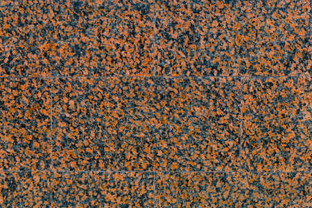 Empty texture of the wall with facing tile of red, spotted, decorative, polished marble with copy space.の写真素材