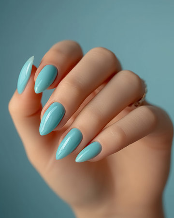 Close up delicate manicure, nails covered with nail polish pastel gently blue color.の素材
