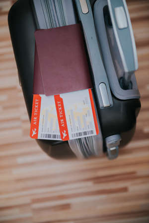 Passport, plane ticket and suitcase ready for vacation.の写真素材
