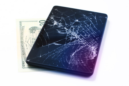 Photos of cracked display on a tablet and 20 dollars isolated on white. Tablet with damaged screen.