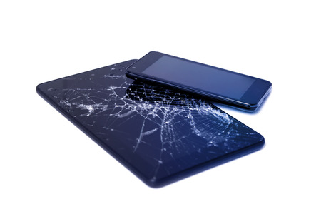 Photos of cracked display on a tablet and black cellphone isolated on white. Tablet with damaged screen.の写真素材