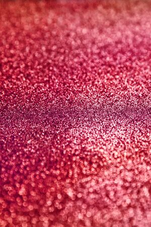 Red  sparkling  background. Abstract twinkled red glittering texture with bokeh, defocused lights for Christmas holiday, banner, wedding invitation and greeting cards.の写真素材