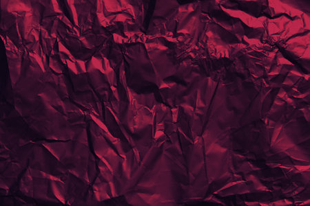 Red crumpled texture background. Dark red Flat lay mockup design. Foil texture sheet abstract background, wrapping texture.の写真素材