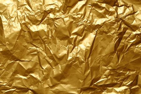Gold crumpled texture background. Abstract banner with shine gold.  Flat lay mockup design. Craft paper texture sheet abstract background, wrapping texture.の写真素材