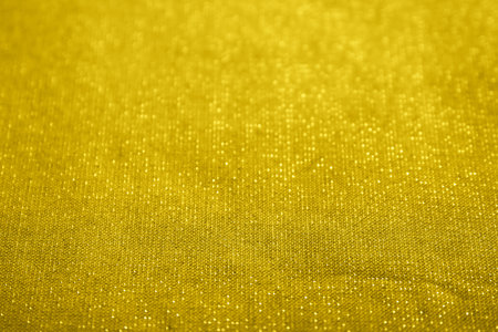 Yellow texture with shiny gold dots. Focus in the center and blur at both ends. Flat lay mockup design. Texture sheet abstract background, wrapping texture.の写真素材
