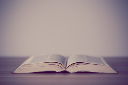 An opened holy bible on a wooden tableの写真素材