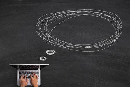 Online Communication concept with hands typing laptop on the blackboard background.の写真素材