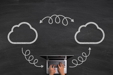 Cloud Technology concept with hands typing laptop on the blackboard background.の写真素材