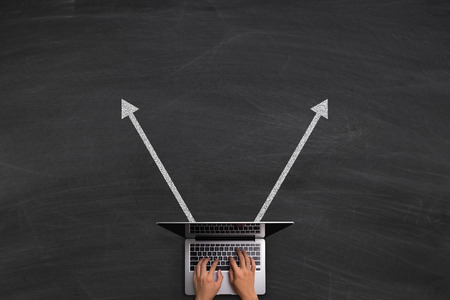 Send Data concept with hands typing laptop on the blackboard background.の写真素材