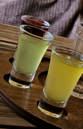 Craft Cocktail Flight on Rustic Wooden Tray
Description: Artisanal cocktail tasting set featuring four signature drinks in miniature glassware arranged on a reclaimed wood tray witの写真素材