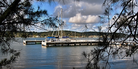 "F" Jetty - Wharf at Lake Macquarie with trees in the foreground and a blue cloudy sky. New South Wales, Australia.Landscape, wharf, trees, water, waterscape, boats, scene, scenic, view, vista, panorama, sky, blue sky, cloud, color, colourful, horizon, hoの写真素材