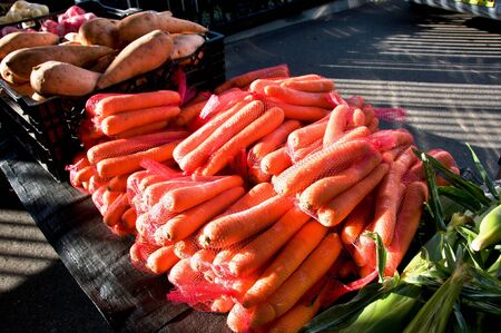 A table display of fresh nutritious vegetables at a farmer's market,  includes, Carrots - (Daucus carota subsp. sativus), and Sweet Potato - (Ipomoea batatas)Market located in Gosford, New South Wales, Australia.の写真素材