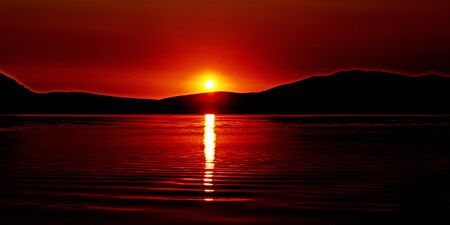Vivid crimson cloud and sky sunrise seascape over Saratoga with water reflections in the tranquil waters of Brisbane Water in Gosford.
New South Wales, Australia.の写真素材