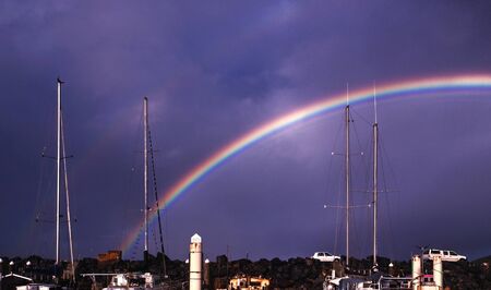 Colourful vivid waterfront rainbow with yacht masts and mooring pylon against the backdrop of a dark blue sky.
Coffs Harbour, New South Wales, Australia.の写真素材