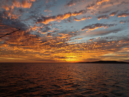 A striking inspirational Orange colored cloudy sunset seascape over sea water with water reflections.
Central Coast, Australia.の写真素材