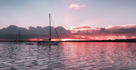 A striking inspirational ( colors ) colored cloudy sunrise  seascape over sea water with water reflections.
Captured in ( LOCATION ), Australia.の写真素材