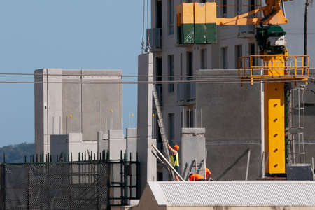 Gosford, New South Wales, Australia - September 11, 2019: Lifting and installing wall panels on High rise building under construction at Mann St, with a blue sky.のeditorial素材