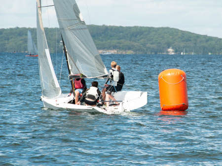 Young boys Sailing  Racing small sailboat, rounding an orange marker. Teamwork by junior sailors racing on saltwater Lake Macquarie. Photo for commercial use.のeditorial素材