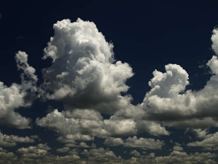 Natural atmospheric photography event. A stormy cloudscape scene, with white and grey threatening Cumulonimbus cloud in a dark blue sky. Nature in action image. NSW, Australia.の写真素材