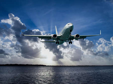 Colourful Australian Cloudscape Seascape with an airborne passenger jet airliner flying high in ...