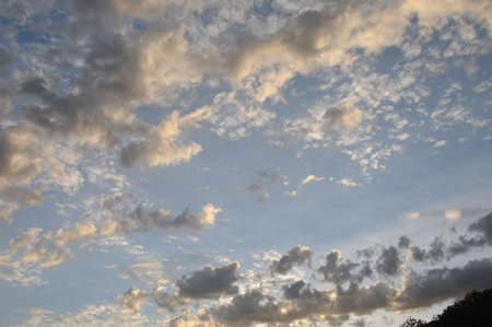 Natural atmospheric photography. A beautiful meteorological sky cloudscape scene, with mixed apricot Cumulus and Altocumulus cloud formations in a blue sky. Beauty in nature. New South Wales, Australia.の写真素材
