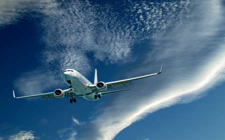 An artistic skyscape view of a commercial passenger jet aircraft flying closeup in a vibrant blue sky, with bright white coloured Cirrocumulus clouds. New South Wales, Australia.のeditorial素材