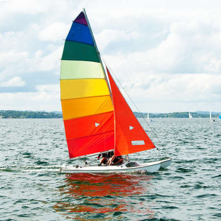 Children sailing in small colourful boats and dinghies for fun and competition. Teamwork by junior sailors racing on salt water Lake Macquarie. Photo for commercial use.の写真素材