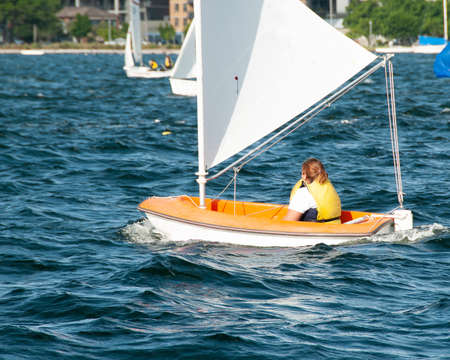 Child sailing in small boat and in competition. Teamwork by junior sailors racing on saltwater Lake Macquarie. Photo for commercial use.の写真素材
